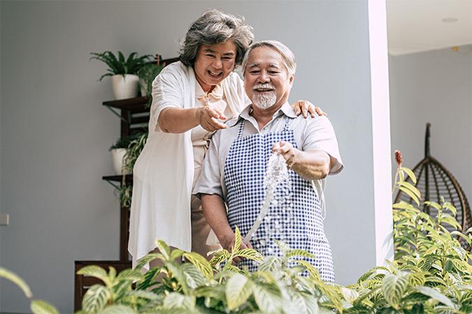 A man and woman watering plants.